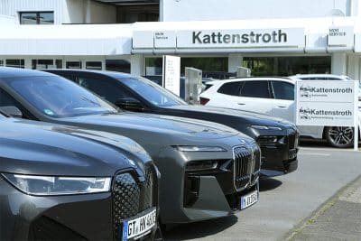 Frontalansicht einer Fahrzeugreihe vor dem Eingangsbereich „Kattenstroth“: Drei BMW-Modelle in verschiedenen Grautönen sind vorn aufgereiht, im Hintergrund das Showroom-Gebäude mit Logo.